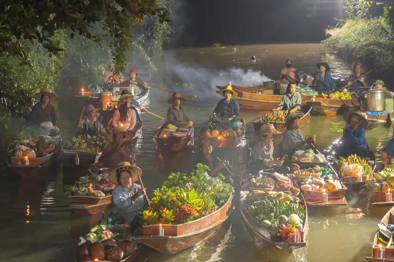 Vendors paddling boats laden with produce at a floating market near Bangkok